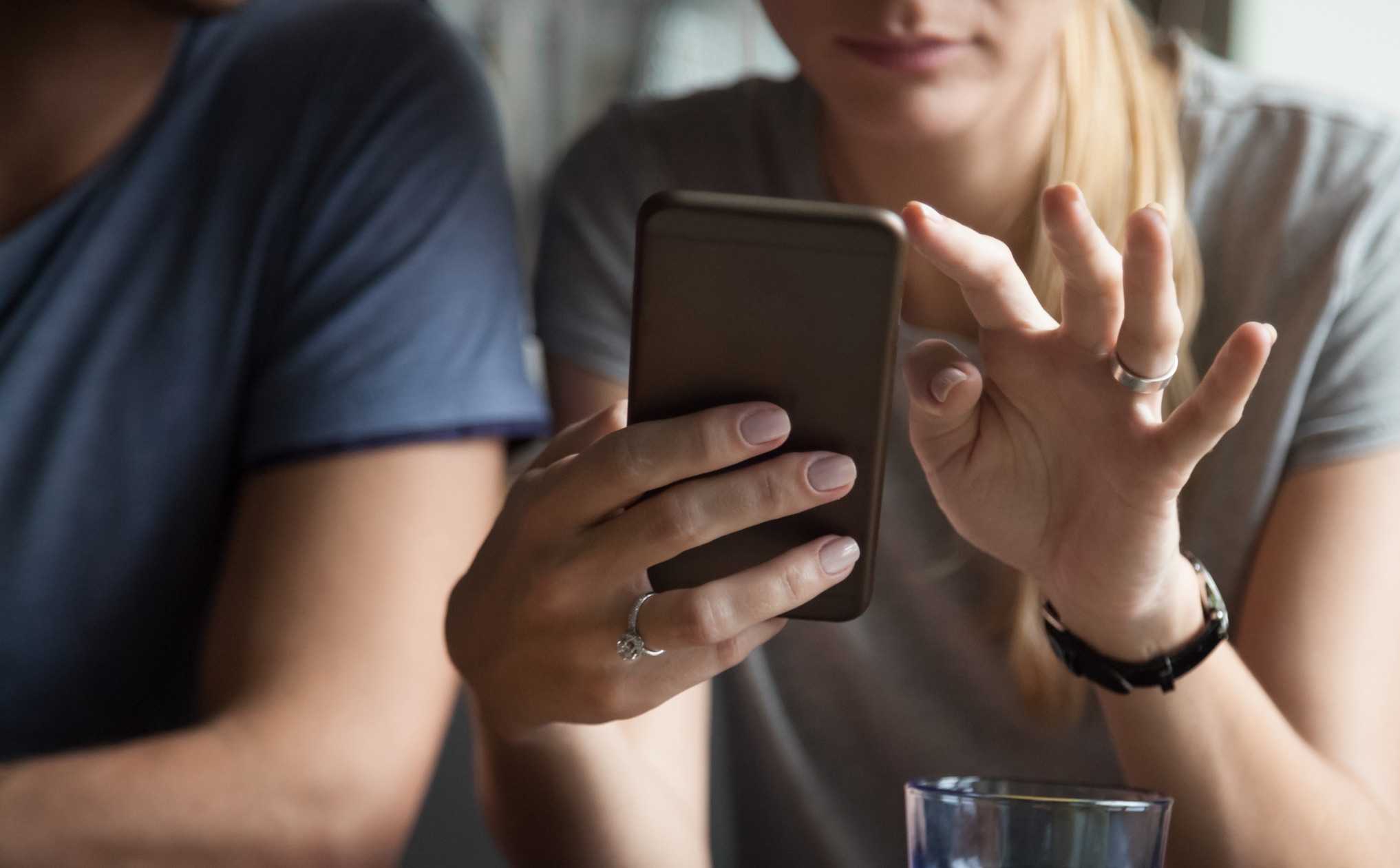 Woman using a smartphone next to companion